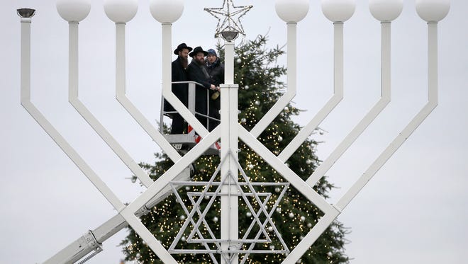 A Hanukkah Menorah stands in front of a Christmas tree at the Brandenburg Gate in Berlin, Germany, in 2014. Many Jews have developed their own cherished Christmas traditions.