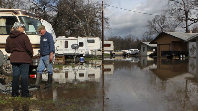Bob Hughes and his wife, Karen, look around at the flooding Tuesday at the Balls Ferry Mobile Home Park. The park where they live was flooded Tuesday after the Sacramento River overran its banks.