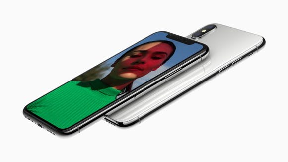 One Apple iPhone X faceup and pointing to the left with another iPhone X, this time face down underneath it.