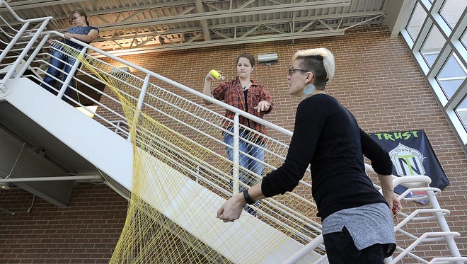 Caity Glover, 16, and Jade Menholt, 16, help Ashley Rieck with a string art installation at New Technology High School in Sioux Falls, SD; Tuesday, Aug. 25, 2015. In the northwest and northeast stairwells, 710 zip ties and 3,500 yards of nylon string were used for the project. Rieck's goal was to put up a fun art piece where string could bring joy to someoneÕs day. She is looking for more project opportunities in the community. Contact Rieck at ashleylynnrieck@gmail.com or (605) 695-9001 if you are interested in a string installation.
