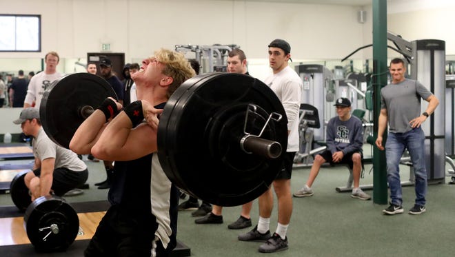 Shasta College running back Justin Hellyer, center, lifts weights with teammates in March on the Redding campus. The Shasta College football program has been moved up to the more competitive National Division after the Knights dominated American Division foes for nearly a half-decade.