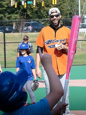 John Star, a player in the Miracle League, shows Boston Red Sox pitcher David Price where he plans to hit the ball. Once his season ended, Price visited with players at the field his foundation helped build.