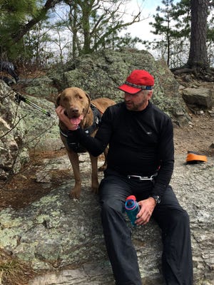 David Paulk and his dog, Abe, take a break from hiking at Calvary Rocks on Riprap Trail at Shenandoah National Park on Saturday, March 26, 2016.