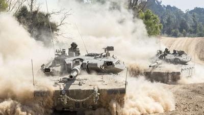 Israeli Merkava tanks roll at an army deployment near Israel's border with the Gaza Strip on July 20, 2014.
