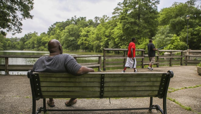 Clifton community members enjoy the view of the lake at Burnet Woods Tuesday afternoon. The 90-acre park attracts members of the community for its walking trails and fishing.