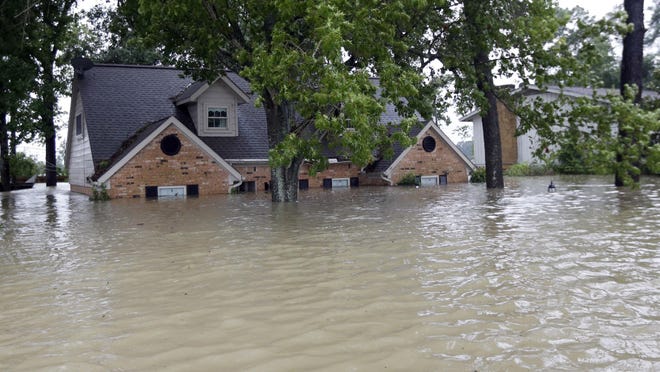A home is surrounded by floodwaters from Hurricane Storm Harvey on Monday in Spring, Texas.