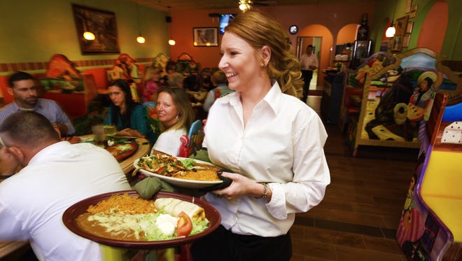 Waitress Karleigh Harris brings entrees to a table at Monterrey in Zanesville. The new Mexican restaurant is on Maple Avenue near Kmart.