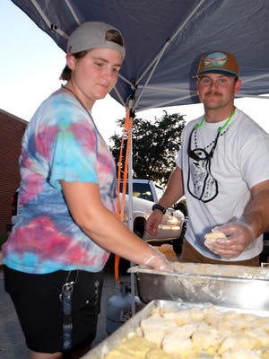 Dyess We Care Team Top 10 Volunteers Senior Airman Erica Hearn and Senior Airman Reese Winters prepare fish for the Cactus Lions Club’s fish fry.