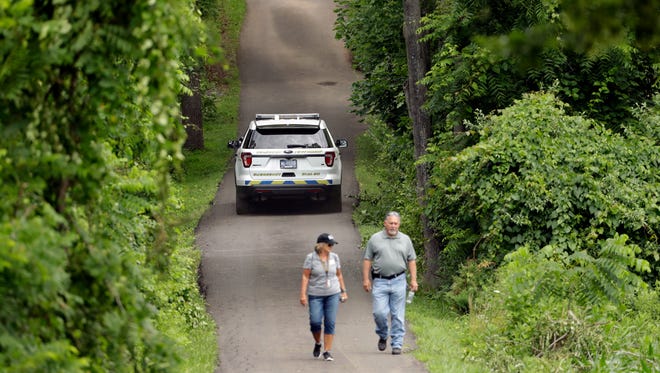 Law enforcement officials walk down a blocked off driveway in Solebury, Pa., as the search resumes Tuesday, July 11, 2017, for four missing young Pennsylvania men feared to be the victims of foul play.