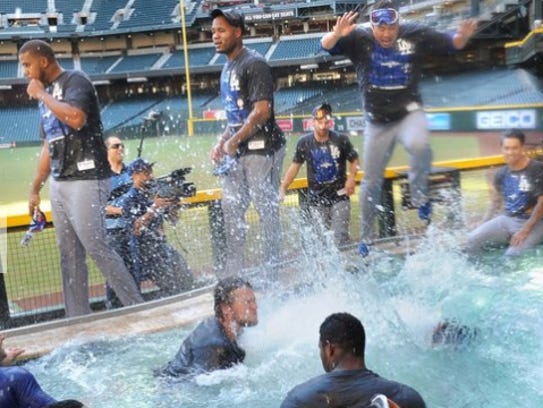 Dodgers players jump into the pool at Chase Field after