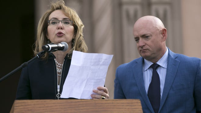 Former U.S. Rep. Gabrielle Giffords speaks, as her husband, Mark Kelly looks on, during the memorial dedication at El Presidio Park in Tucson on Monday, Jan. 8, 2018. The dedication was held on the 7 year anniversary of the Tucson mass shooting that left 6 people dead and 13 others injured including Giffords. The memorial is expected to be completed within the next two years.