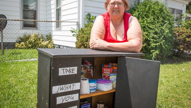 Jeannetta Presley stands with her blessing box on Wednesday at  at the corner of East Eighth and South Monroe streets in Muncie. The box is stocked with non-perishable food items and basic toiletries for those in need.