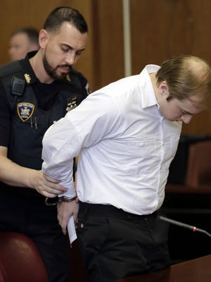James Jackson is handcuffed after his sentencing in New York, Wednesday, Feb. 13, 2019. Jackson, a white supremacist, pled guilty to killing a black man with a sword as part of a racist plot that prosecutors described as a hate crime and was sentenced to life in prison without parole. (AP Photo/Seth Wenig)