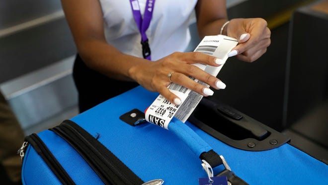 A Delta Air Lines employee places an RFID-enabled baggage tag on a passenger's checked bag at Baltimore-Washington International Thurgood Marshall Airport in Linthicum, Md. If an airline forces a passenger off a flight for lack of space, under federal rules the passenger is entitled to cash compensation, not just a voucher, and a seat on a later flight. Bumped passengers whose travel is delayed for at least an hour are entitled to up to $1,350 in compensation, with the amount based on the length of the delay and the one-way price of the ticket. Delta vouchers can be applied to government taxes.