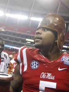 Mississippi defensive tackle Robert Nkemdiche carries the trophy off the field after Mississippi defeated Boise State 35-13 in an NCAA college football game Thursday, Aug. 28, 2014, in Atlanta. (AP Photo/John Bazemore)