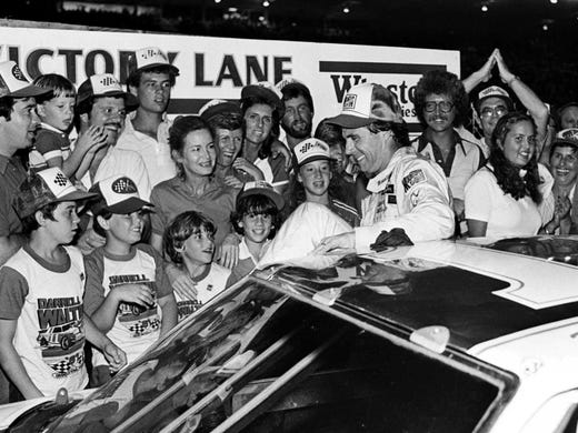 Darrell Waltrip climbs out of his car in victory lane