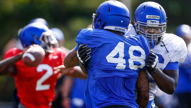 University of Memphis offensive lineman Roger Joseph (right) blocks teammate Ernest Suttles (left) during practice Monday afternoon. 