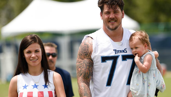 Titans left tackle Taylor Lewan walks with his wife, Taylin, and daughter, Wynne, after practice Thursday at Saint Thomas Sports Park.