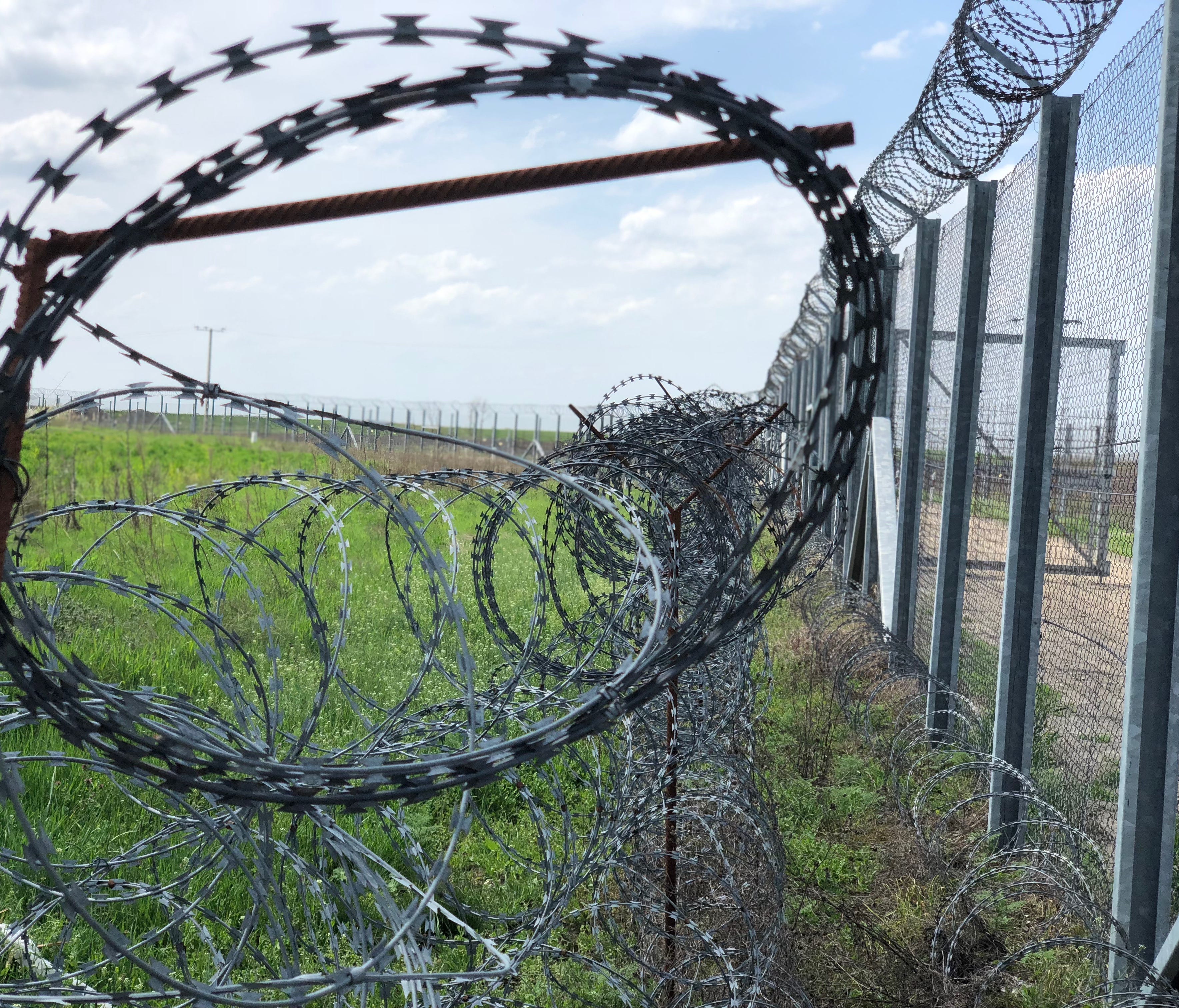 Barbed wire is seen near the end of border fence in Hungary near the country's international boundary with Serbia and Romania, on April 13, 2018.