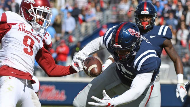 Arkansas defensive back Santos Ramirez (9) strips the ball from Ole Miss tight end Octavious Cooley (15) during the first half.