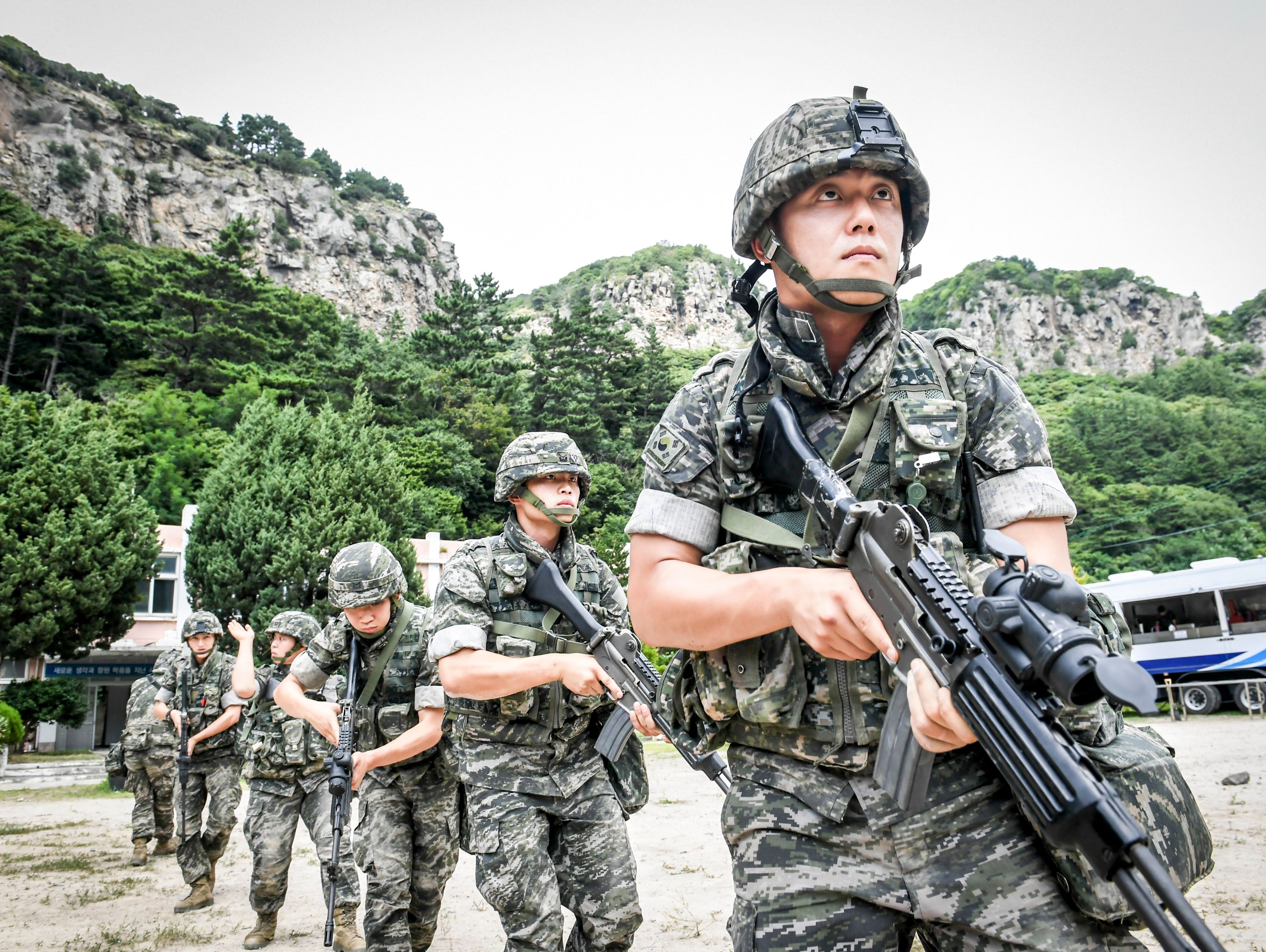 A handout photo made available by the South Korean Marine Corps shows South Korean Marines patrolling along the coast of the eastern island of Ulleung as they take part in the largest-ever training to defend the island, some 75 miles off the eastern 