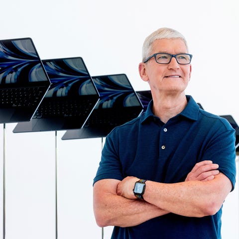 FILE - Apple CEO Tim Cook stands in front of a dis