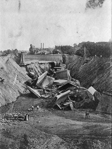 Workers inspect the damage caused by a collapsed culvert