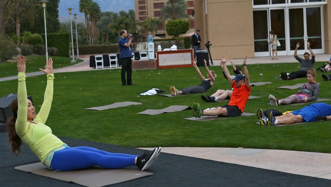 Cassey Ho, left, leads the morning workout during the Clinton Foundation Health Matters Summit in Indian Wells, Monday, January 26, 2015. 