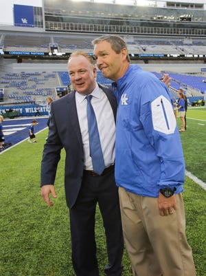 Kentucky head coach Mark Stoops, left, visits with Kentucky Athletic Director Mitch Barnhart on the field after arriving at Commonwealth Stadium for an NCAA college football game against Florida, Saturday, Sept. 19, 2015, in Lexington, Ky. Florida won the game 14-9.