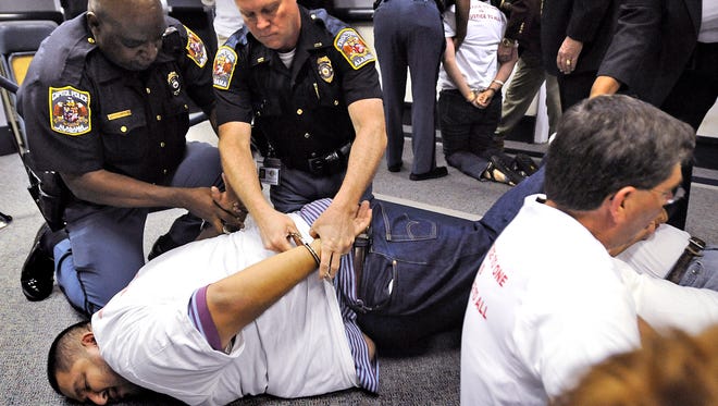 Alabama Capitol Police handcuff immigration law protesters outside of the senate chamber at the Alabama Statehouse in May 2012. A new study suggests that increased incarceration has had little to no effect on the decline of crime in the last two decades.