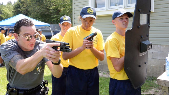 Nick Rehrig, a member of the Bridgeton Police Tactical Entry team (left), instructs Steve Schemelia, of Pittsgrove, 14 (right), and Tamia Taylor, 16, of Mays Landing, during a Cumberland County Youth Week training session at the Cumberland County Technical Education Center last August.