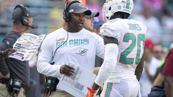 Dolphins coach Brian Flores talks with safety Reshad Jones.