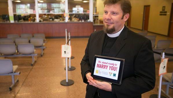 Rev. Eric Ledermann uses an iPad to advertise that he is ready to perform gay marriages at a Chandler courthouse.