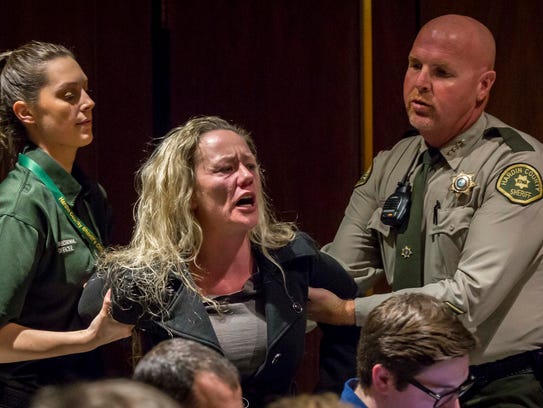 A woman is escorted out of court for an outburst during