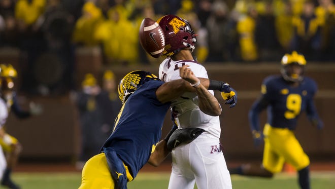 Michigan defensive back Khaleke Hudson forces Minnesota quarterback Demry Croft to fumble the ball in the third quarter. Michigan recovered the fumble.