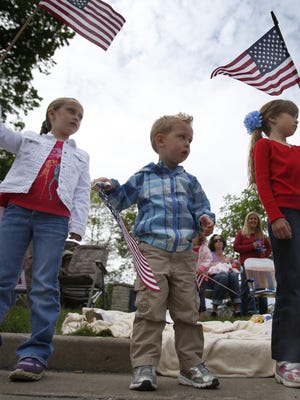 Aybrey Reed, left, Jack Dauman and Lucie Fouts wave flags during the 2013 Appleton Memorial Day parade.
