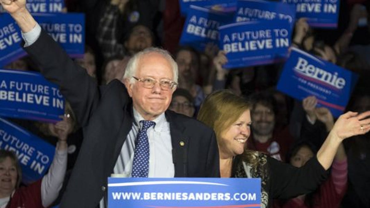 Democratic presidential candidate Sen. Bernie Sanders, I-Vt., and his wife, Jane, acknowledge the crowd as he arrives for his caucus night rally in Des Moines on Monday, Feb. 1, 2016.