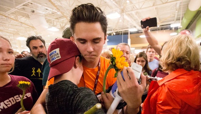 Marjorie Stoneman Douglas High School students David Hogg, center rear, and Caspen Becher, hug after a demonstration at a Publix Supermarket in Coral Springs, Fla., May 25. Students from the Florida high school where 17 people were shot and killed earlier this year did a "die in" protest at a supermarket chain that backs a gubernatorial candidate allied with the National Rifle Association. Shortly before the the "die-in" Publix announced that is will suspend political donations.