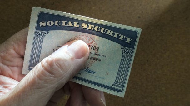A Social Security card being held in a person's...