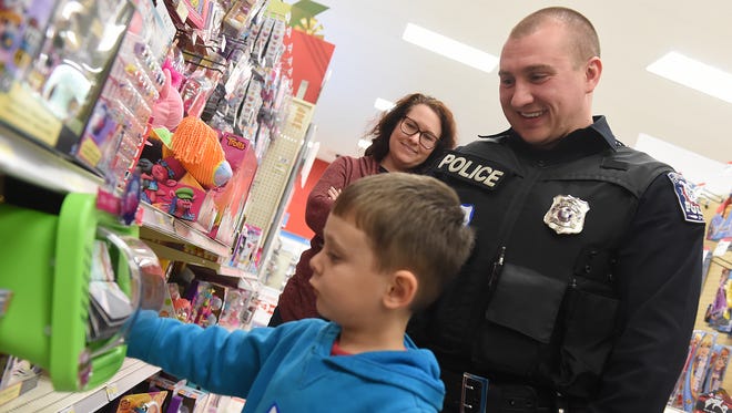 West York Borough police officer Sean Hightman laughs as 5-year-old Keon Breen plays with a toy in the aisles at the Target Store on Tuesday. The duo was paired up during the "Shop with a Cop" event at the West Manchester Township store.