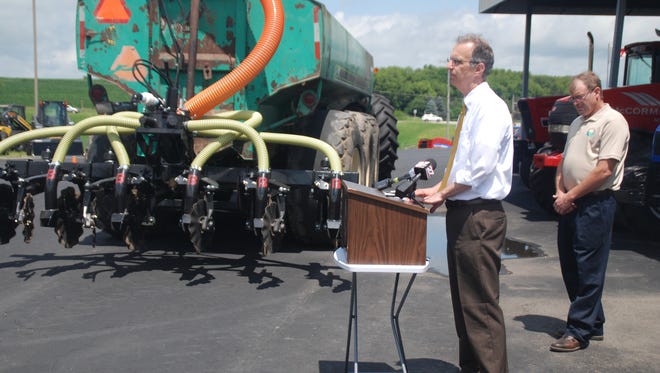  Dane County Executive Joe Parisi, at podium, and Jeff Endres, chairman of Yahara Pride Farms, a farmer-led conservation non-profit organization, showed farmers a Low Disturbance Manure Injection system being purchased by the county and other supporters so farmers will have it available to more safely inject their manure and protect the watershed.