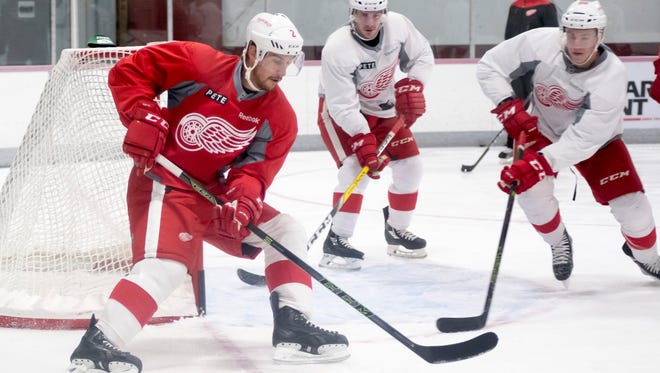 Defenseman Brendan Smith, left, keeps the puck away from the other players during practice.