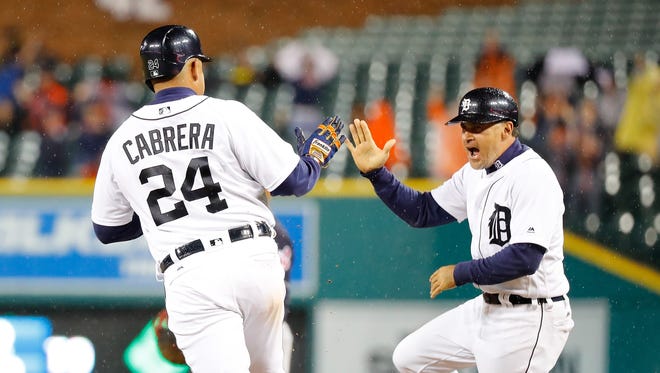 Tigers' Miguel Cabrera hits a three-run home run and celebrates with first base coach Omar Vizquel during the fifth inning against the Cleveland Indians on September 28, 2016 at Comerica Park in Detroit.
