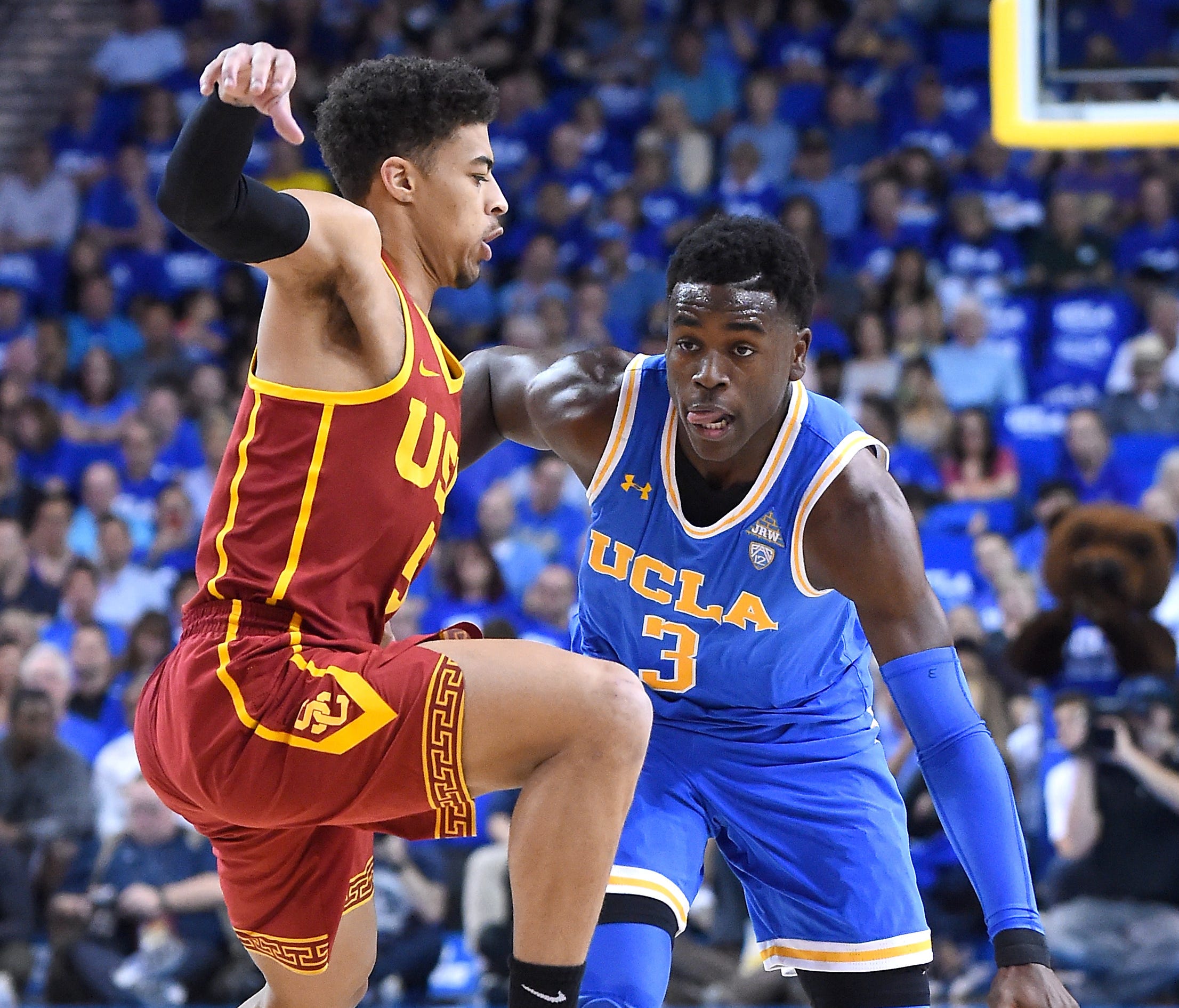 Derryck Thornton of the USC Trojans guards Aaron Holiday of the UCLA Bruins.