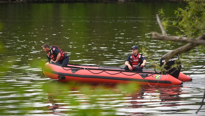 Firefighters use an inflatable boat to search a section of the Mississippi River along Fifth Avenue North Wednesday, May 23, in St. Cloud.