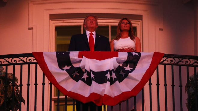 President Donald Trump and first lady Melania Trump stand on the Truman Balcony of the White House as they watch a fireworks display during a "Salute to America" event, Saturday, July 4, 2020, in Washington.
