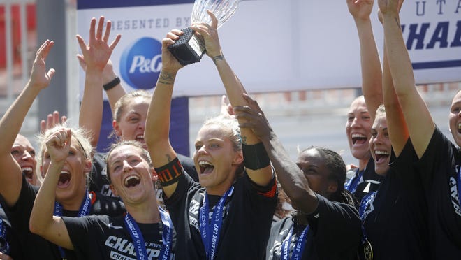 Houston Dash forward Rachel Daly holds the trophy alongside teammates as they celebrate their Challenge Cup championship win over the Chicago Red Stars on Sunday in Sandy, Utah.