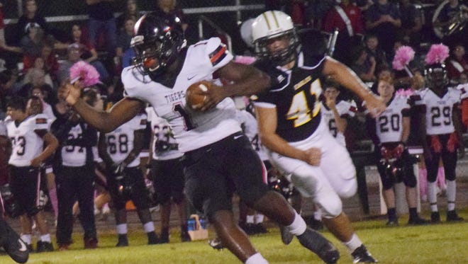 Many running back Terrence Williams (1) picks up a first down against Menard in last season's game.