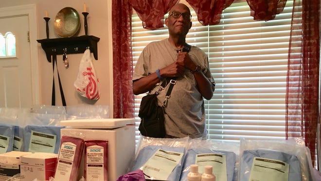 Inside his Staunton home on Thursday, July, 19, 2018, Tom Davis stands beside his dining room table covered with medical consumables that must be used every day for his bridge to transplant care until he receives a new heart.