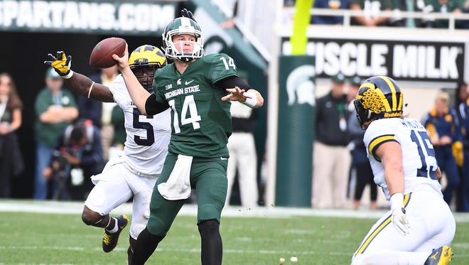 Michigan State Spartans quarterback Brian Lewerke (14) attempts a pass as Michigan Wolverines linebacker Jabrill Peppers (5) defends during the second half at Spartan Stadium.